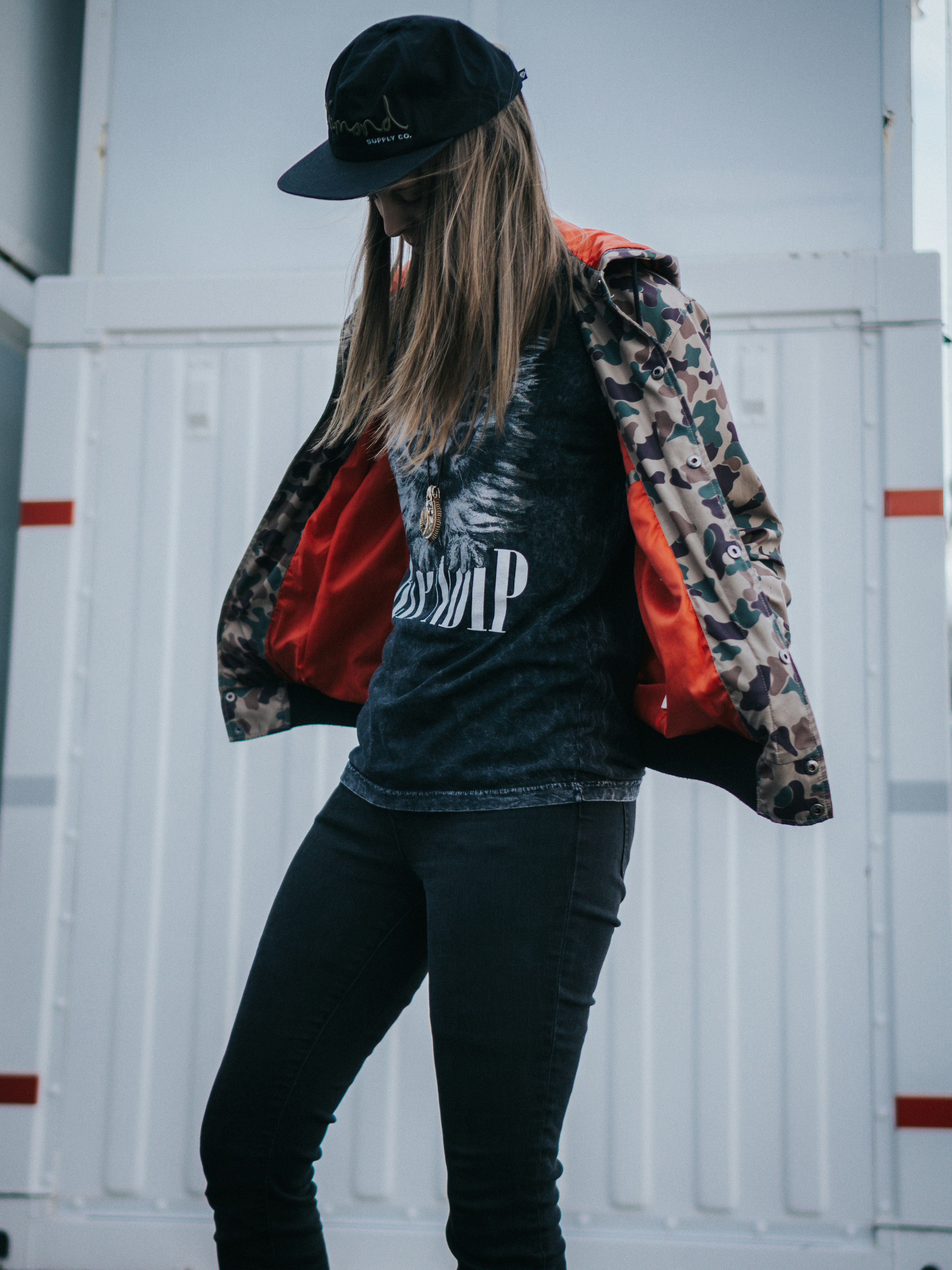 woman in black and red jacket and black pants wearing black cowboy hat